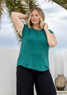 Woman wearing a soft flattering fit green rayon jersey t-shirt.