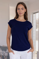 Woman wearing a navy blue soft stretch rayon jersey t-shirt and white pants