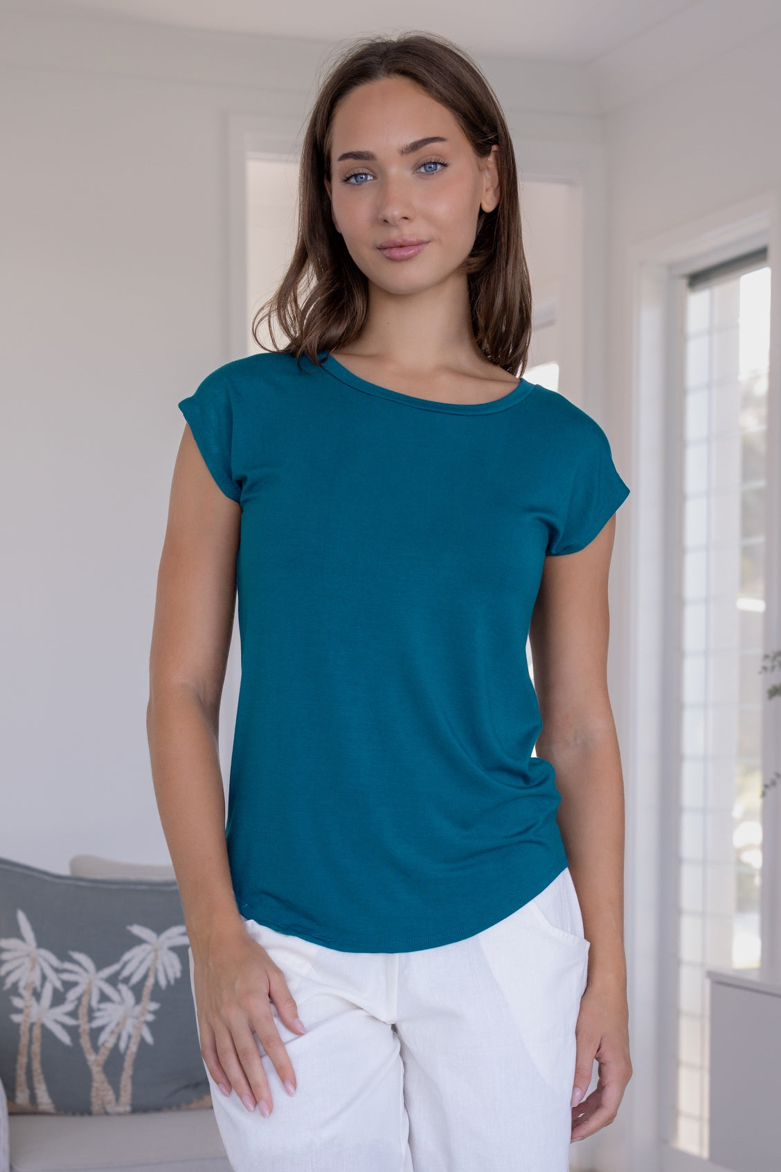 Woman wearing a teal stretch rayon jersey t-shirt and white pants