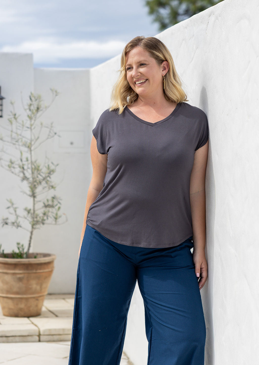 Woman wearing a dark grey v-neck short cap sleeve rayon top