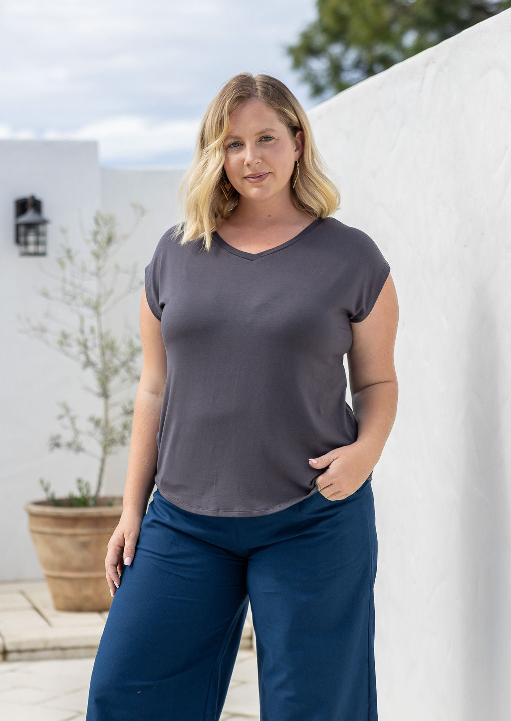 Woman wearing a dark grey v-neck short cap sleeve rayon top