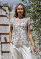 Woman wears cotton floral print cap sleeve top paired with white cotton pants
