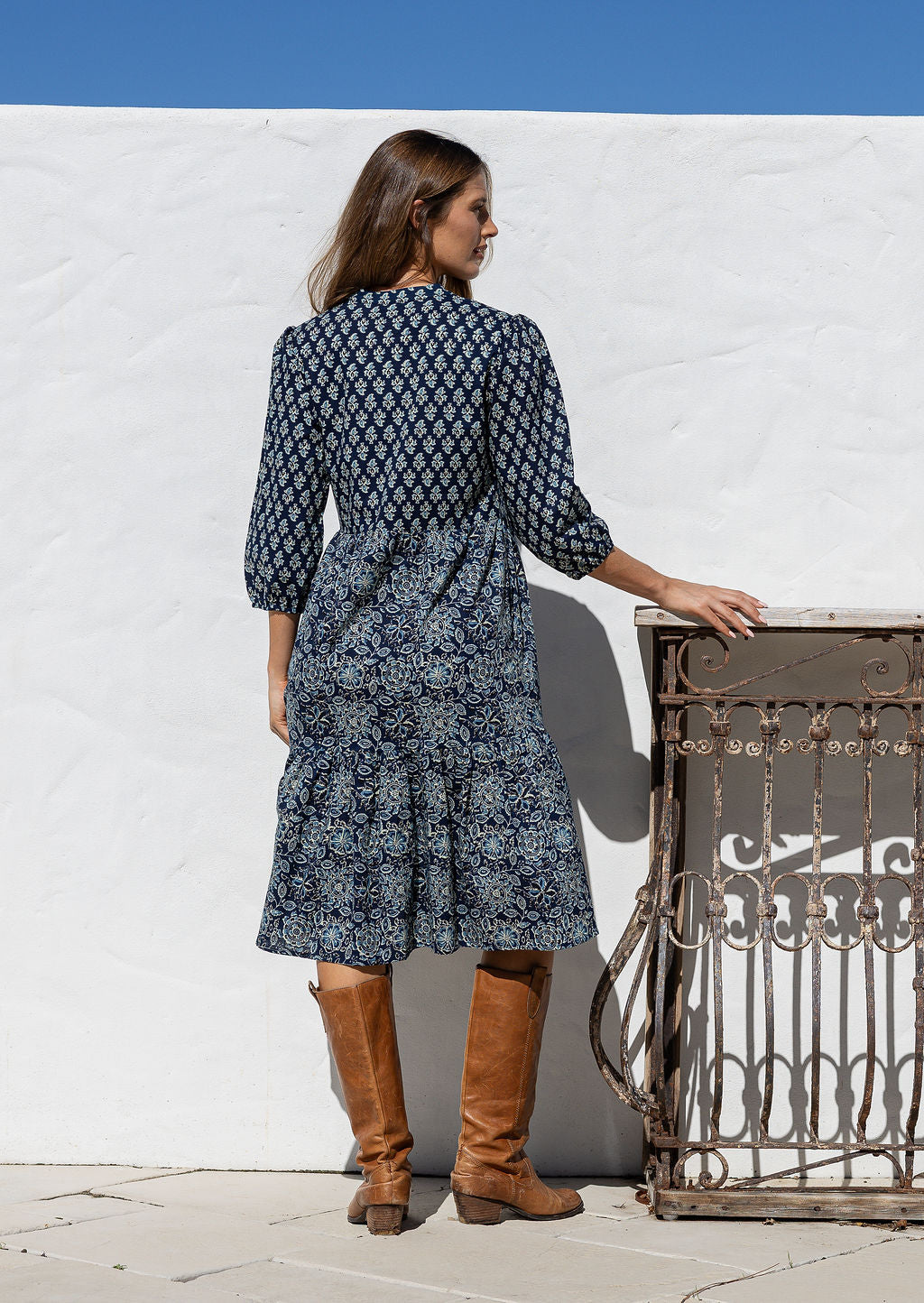 Model stands backwards on in cotton over the knee length relaxed fit dress with 3/4 sleeves, paired with brown boots. 