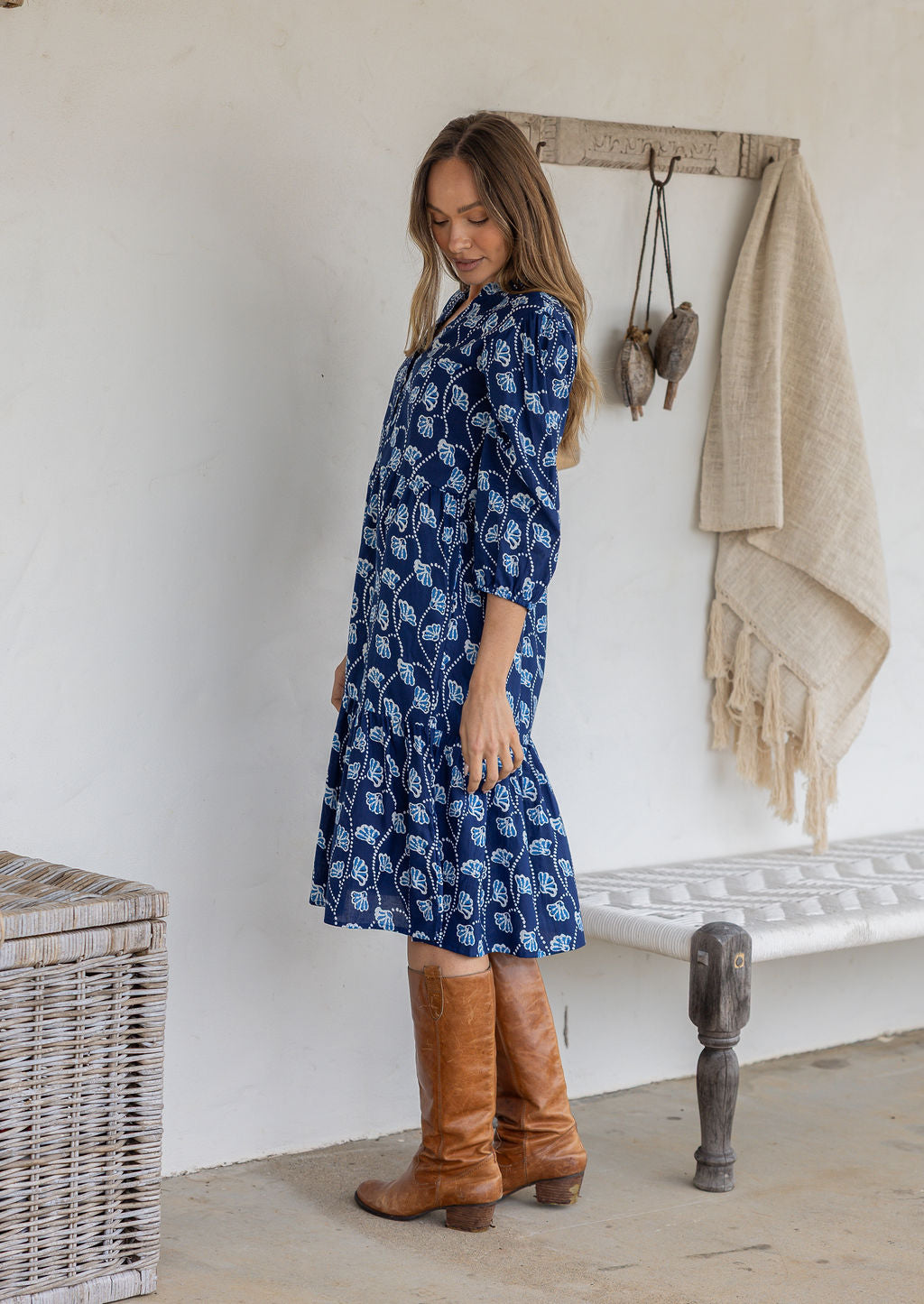 Model stands side on in cotton over the knee length relaxed fit dress with 3/4 sleeves, paired with brown boots.