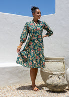 Woman flaunting cotton tiered dress in green  floral print, with 3/4 sleeves, buttoned bodice and V-neckline
