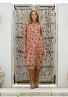 Woman wearing a 100% cotton floral dress with 3/4 sleeves and pockets 
