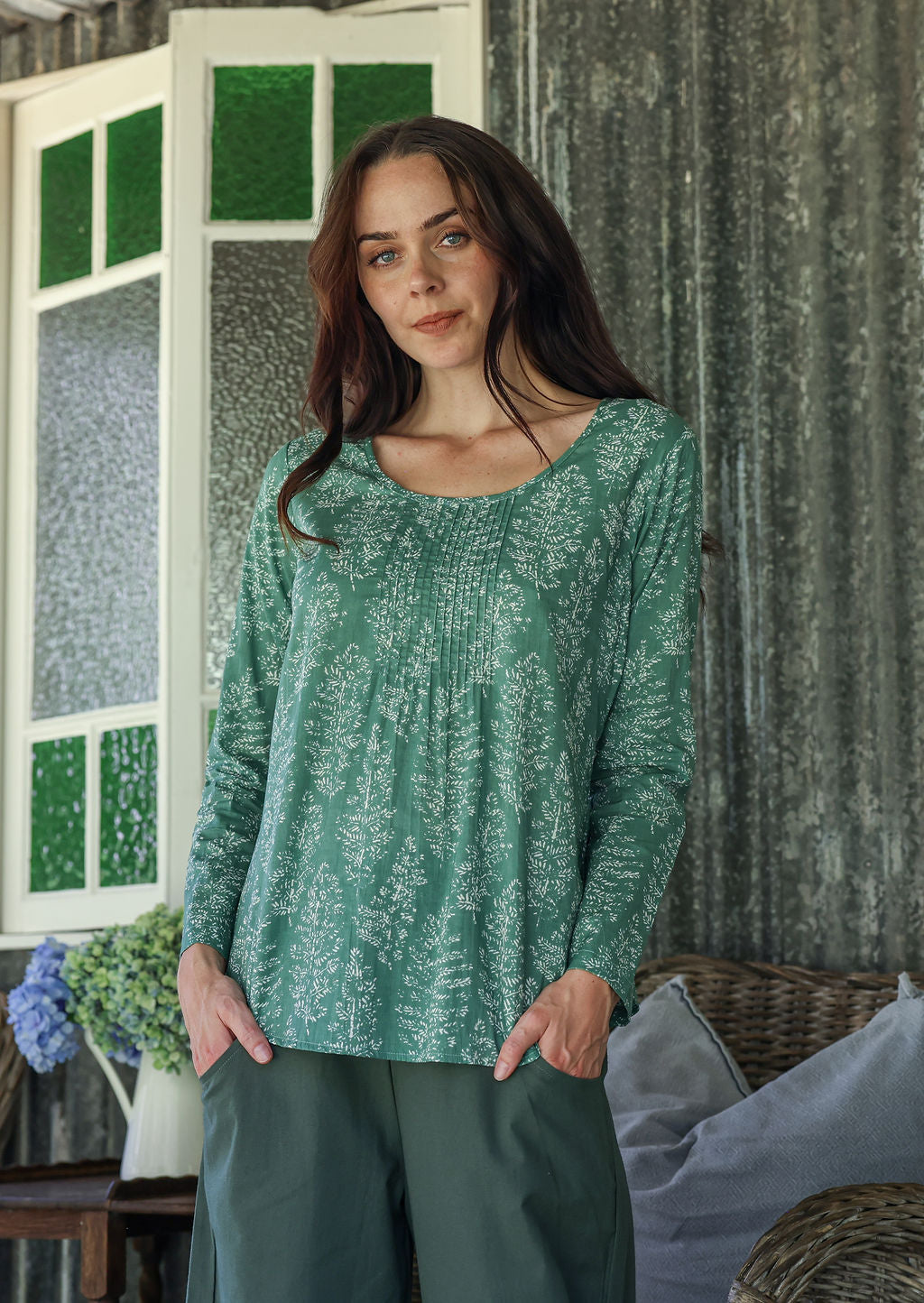 Model wearing a flattering long sleeve top with beautiful sage green based florals.