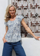 Woman wearing a floral cotton top in natural white with blue floral print, paired with sea blue cotton pants