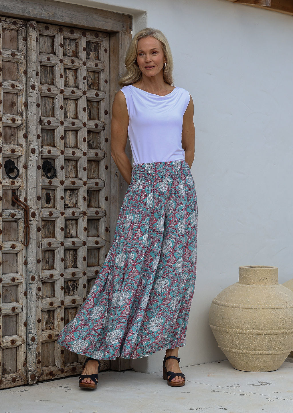 Woman wearing a white top and floral printed wide leg rayon pants with elasticated waistband