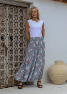 Woman wearing a white top and floral printed wide leg rayon pants with elasticated waistband