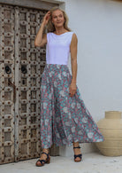 Woman posing in wide leg floral print palazzo pants with a smocked elastic waistband.