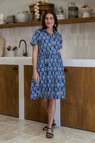 Woman wearing a 100% cotton navy blue base floral print relaxed fit collared short sleeve dress.