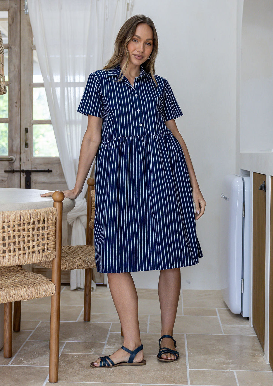Woman wearing a 100% cotton navy blue base white striped print relaxed fit collared short sleeve dress.