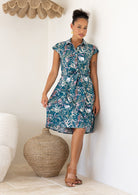 woman wearing the Ursula Dress fit and flare style in Verdure, a teal cotton shirt dress with wildflower print 