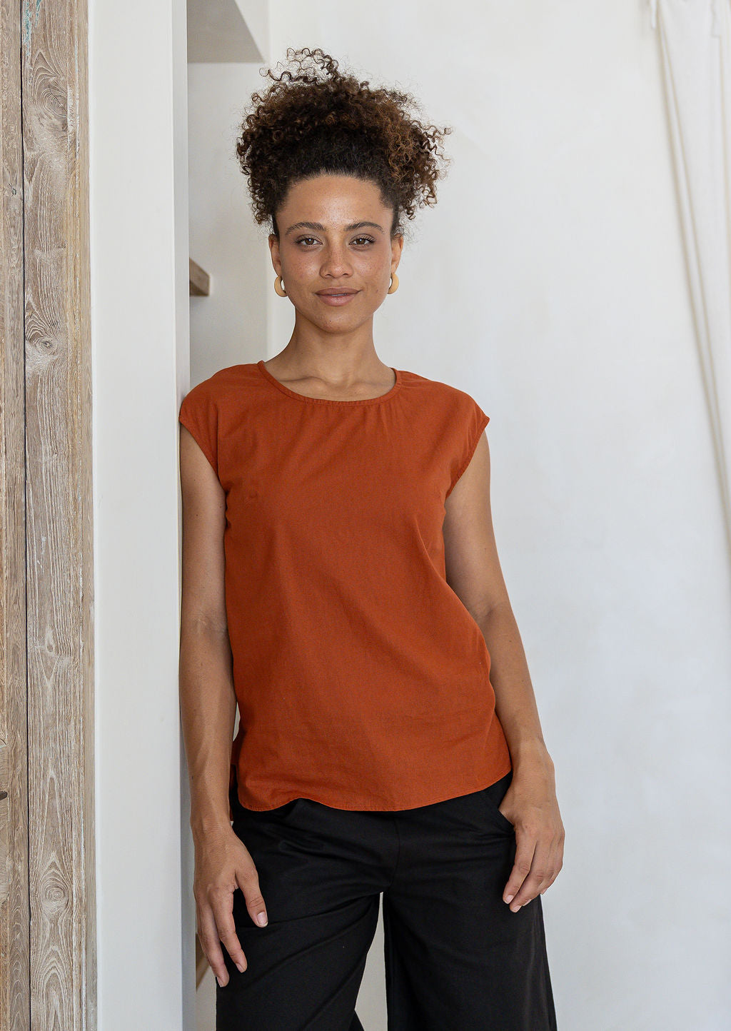 woman wearing 100% cotton top with round neckline in orange brushetta colour. 