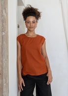 woman wearing 100% cotton top with round neckline in orange brushetta colour. 