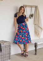 Woman wearing a basic navy top and royal blue based floral a-line cotton skirt with side zipper 