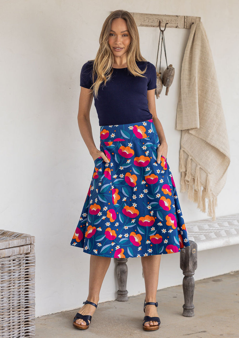 Model wearing 100% cotton knee length A-line skirt with side zipper and pockets in royal blue based floral print