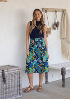 Woman wearing a basic navy top and navy based floral a-line cotton skirt with side zipper 