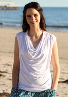 Woman wearing a white cowl neck rayon top.