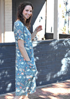 Woman with dark brown hair walking in cotton relaxed fit over the knee length dress with hand in pocket