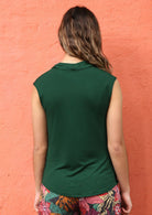 Back view of woman wearing forest green cowl neck rayon top.