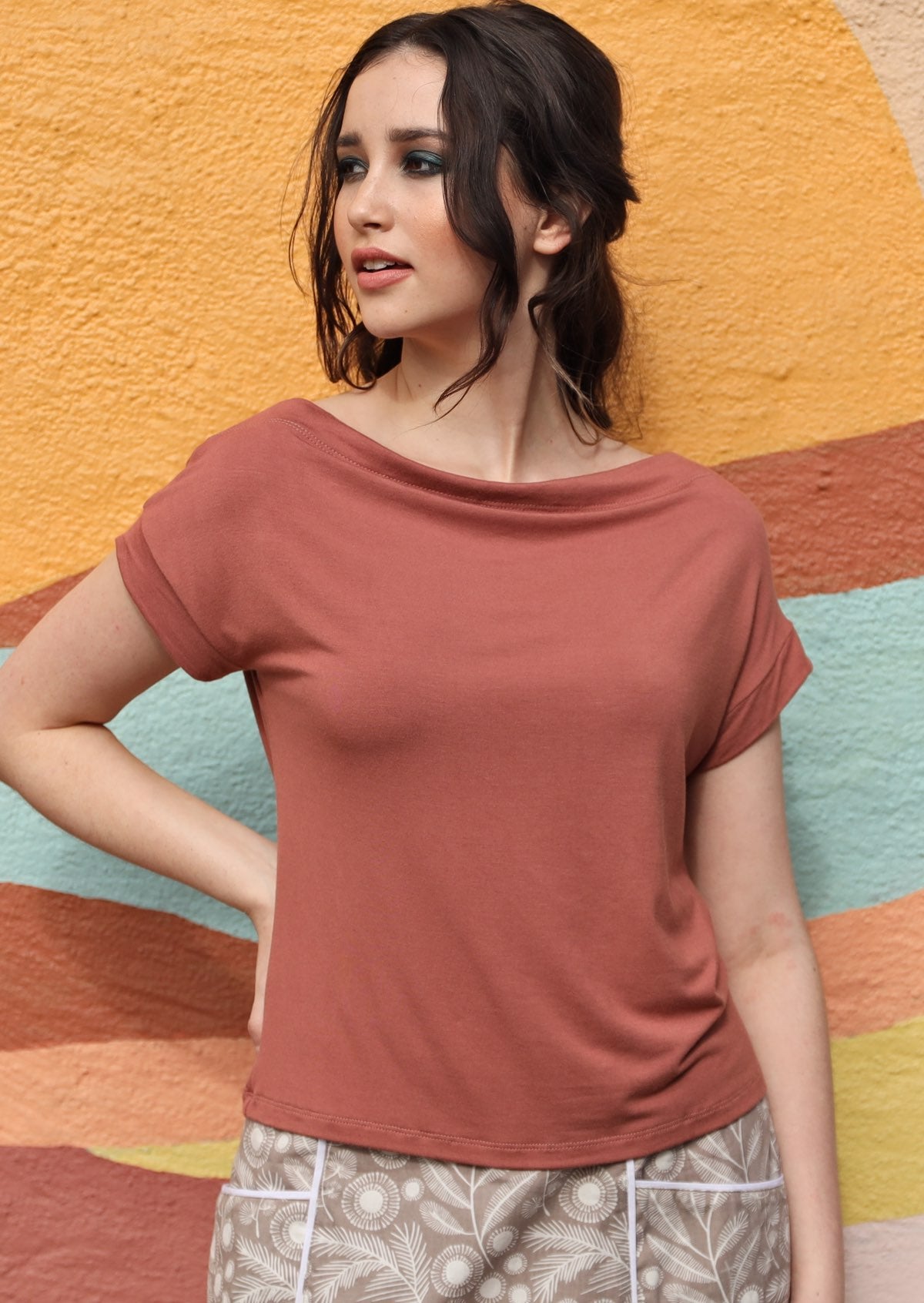 Woman wearing a wide neck mod dusty rose stretch rayon boat neck top